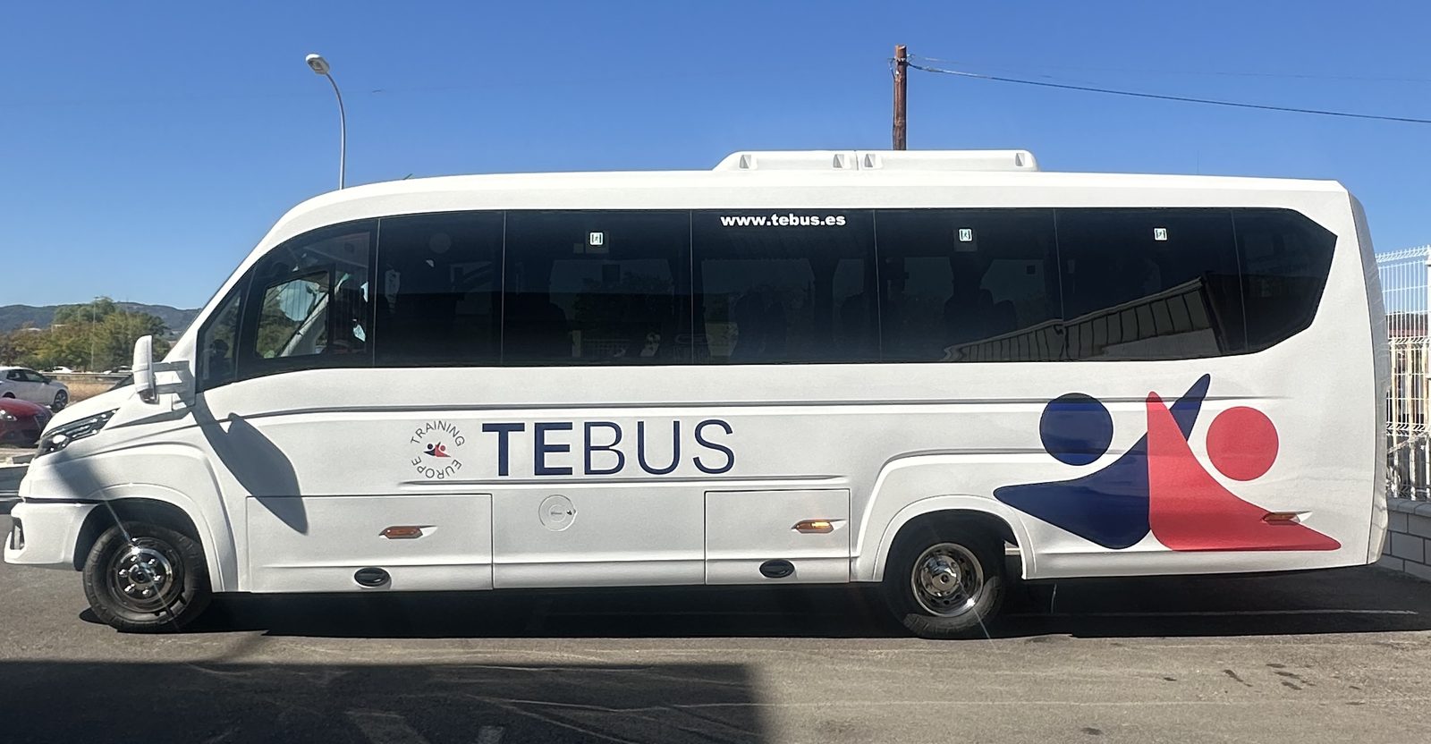 Autobús de TE Bus rotulado, visto de lado